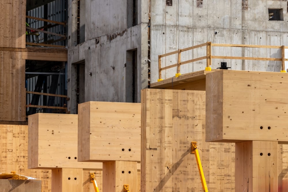 GlueLaminatedWallPanelOnMassTimberBeamsAndPosts Glue-laminated wall panels and mass timber framing installed in a multi-story building, illustrating engineered wood construction systems used for durable, long-term building performance.